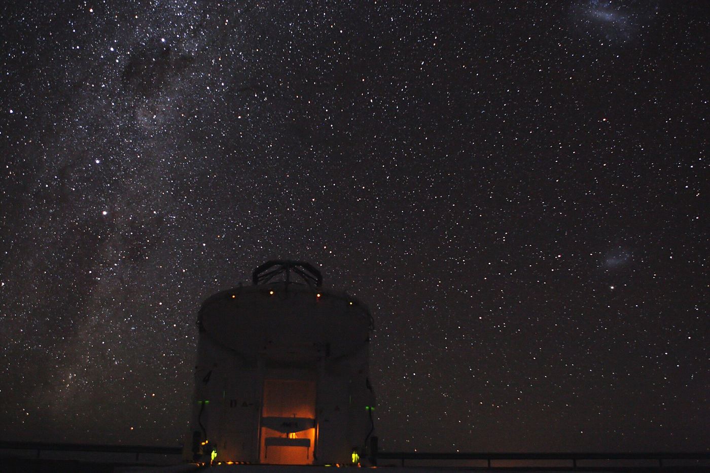 telescope silhouetted under a star-filled night sky
